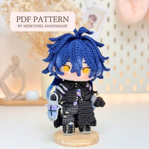 May include: A crochet doll with spiky dark blue hair and bright yellow eyes, wearing a detailed black outfit with purple and white accents. The doll holds a small blue lantern and stands on a round wooden base. Text reads PDF PATTERN BY MEIKYNIEL.HANDMADE.