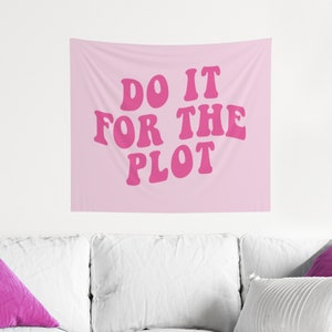 以下が含まれることがあります： レトロなフォントで「DO IT FOR THE PLOT」と書かれたピンクのタペストリー