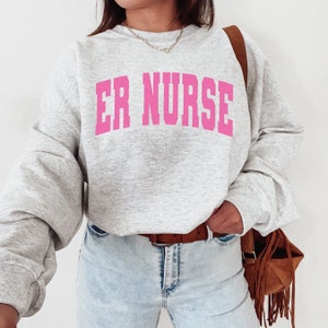 May include: A gray sweatshirt with the text "ER NURSE" in pink letters.
