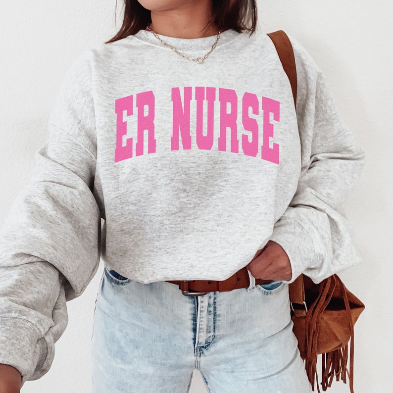 May include: A gray sweatshirt with the text "ER NURSE" in pink letters.