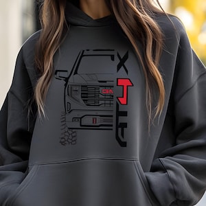 May include: A gray hooded sweatshirt with a black and white graphic of a truck with the text "GMC" and "XT" on it.