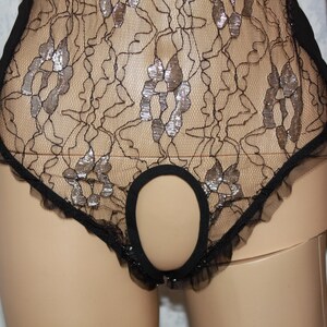 May include: Black lace lingerie with a cutout detail. The lace has a silver shimmer.