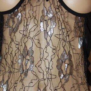 May include: Black lace lingerie with silver accents. The lace has a floral pattern.