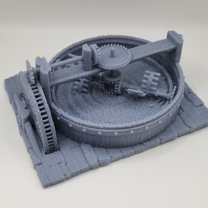 Peut inclure: Modèle imprimé en 3D gris d'un moulin à broyer de style médiéval avec une base en bois et une roue métallique rotative.