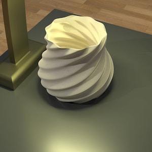 May include: A white ceramic vase with a swirling, spiral design. The vase is sitting on a dark green surface.