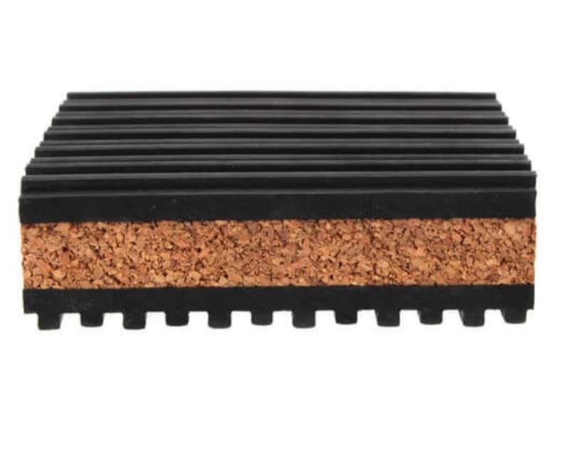 May include: A rectangular coaster with a layered design. The top and bottom layers are black with a ridged texture, while the middle layer is natural cork. The coaster is designed to protect surfaces from heat and moisture.