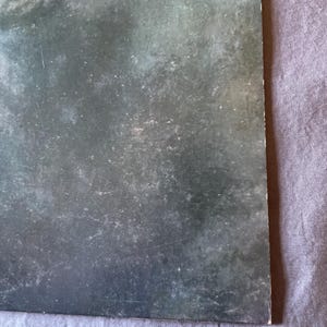 以下が含まれることがあります： テクスチャ加工された表面を持つダークグレーのビニールレコードアルバムカバー