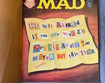 Puede incluir: Una portada de la revista MAD vintage con un papel amarillo con las palabras "WE HAVE ALFRED. if you ever WANT TO See Him Again You BETTER BUY this Issue." La portada también presenta a un hombre de dibujos animados con una expresión de sorpresa y el texto "MAD" en letras rojas grandes.