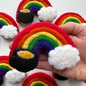 May include: A set of felt rainbow decorations with a pot of gold at the end of each rainbow. Each rainbow is made of red, orange, yellow, green, blue, indigo, and violet felt. The decorations are ideal for a St. Patrick's Day or rainbow-themed party.
