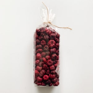 May include: A clear plastic bag filled with dried red and burgundy flower buds, tied with twine.
