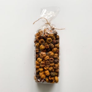 May include: A clear plastic bag filled with dried orange and brown potpourri. The bag is tied with a brown twine string.