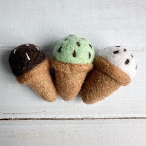 Könnte beinhalten: Drei Filz-Eiswaffeln, eine Schokolade, eine mintgrün und eine weiß mit Schokoladenstreuseln.