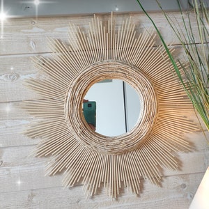 Ronde spiegel van natuurlijk hout, omringd door concentrische cirkels in een zeer trendy en bloemig materiaal