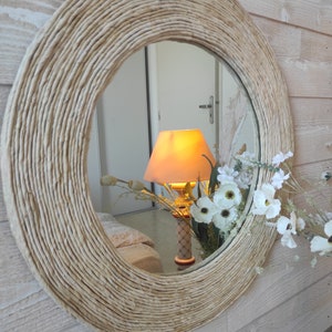 French designer. Large round mirror surrounded by wood covered with ecru corn rope