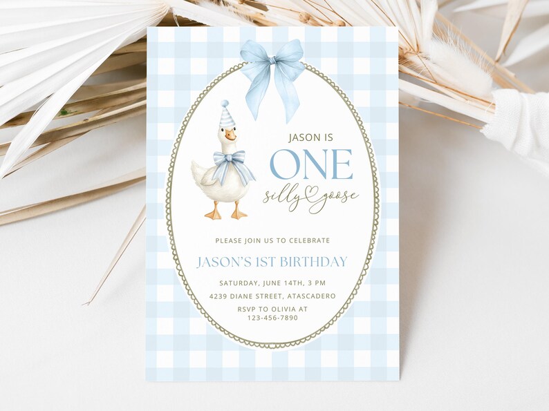 May include: A rectangular birthday invitation card with a light blue and white gingham pattern. It features a central oval frame with a light blue bow, a goose wearing a party hat and bow tie, and text reading JASON IS ONE silly goose, PLEASE JOIN US TO CELEBRATE JASON'S 1ST BIRTHDAY, SATURDAY, JUNE 14TH, 3 PM, 4239 DIANE STREET, ATASCADERO, RSVP TO OLIVIA AT 123-456-7890.