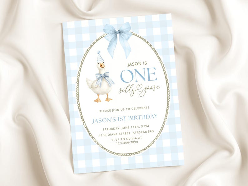 May include: A rectangular invitation card with a light blue and white gingham background. It features a white oval frame with a gold border and a light blue bow at the top. Inside, a goose wears a party hat and bow, with text reading JASON IS ONE silly goose, JASON'S 1ST BIRTHDAY, and event details.