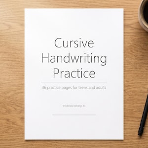 May include: A white workbook titled Cursive Handwriting Practice with the subtitle 36 practice pages for teens and adults and a line for this book belongs to. A black pen is positioned to the right of the book on a light brown wood surface.