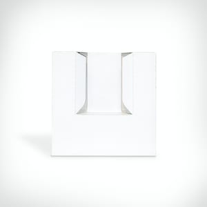 May include: White cardboard box with two cut-out slots on the front. The box is designed to hold a product, such as a bottle or a candle.
