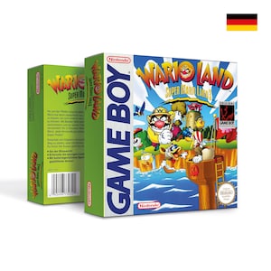 May include: A green and blue Game Boy Color game cartridge case for Wario Land: Super Mario Land 3. The front of the case features a cartoon image of Wario and other characters from the game. The back of the case has text in German.