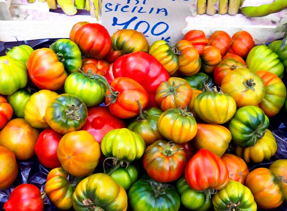 Photo of fresh tomatoes for sale in an outdoor market in Italy.