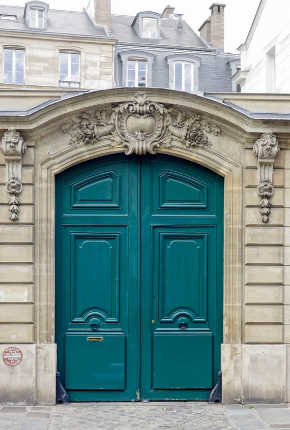 Imposing double teal blue doors to a Parisian courtyard.