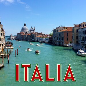 May include: A picturesque canal scene in Venice, Italy, featuring boats and buildings along the water's edge. The water is a striking turquoise, and the sky is a clear blue. The word "ITALIA" is displayed in large red letters with a green border.