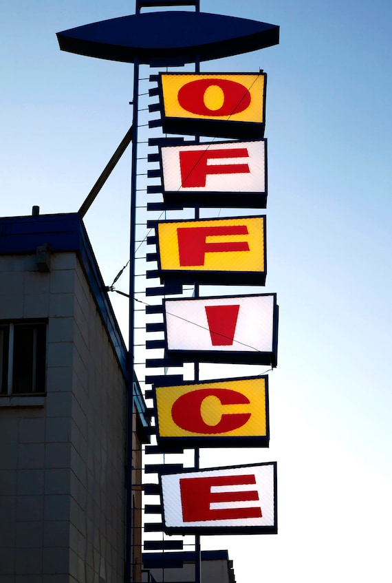 Lit motel office sign at dusk, US.