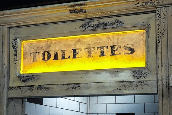 Antique toilettes sign in Paris bar.