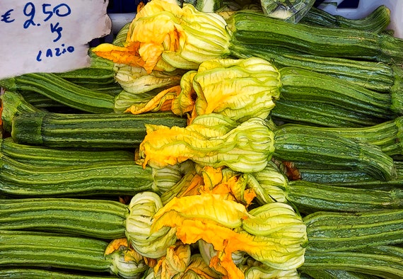 Photo of flowering zucchini for sale at outdoor market in Italy.
