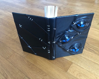 Carnet relié en cuir avec des yeux