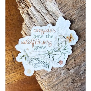 May include: White sticker with a watercolor illustration of wildflowers and the text "consider how the wildflowers grow. Psalm 46:5"