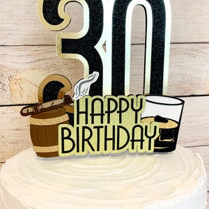 May include: Black and gold glitter cake topper with the number 30, a cigar, a barrel, a glass of whiskey, and the text "Happy Birthday".