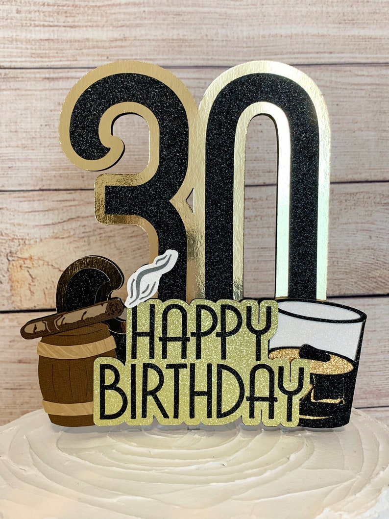 May include: Black and gold glitter cake topper with the number 30, a cigar and barrel, a glass of whiskey, and the words "Happy Birthday".