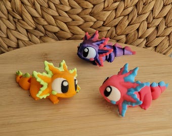 Juguete o llavero de ajolote impreso en 3D en rosa, naranja y morado. Ajolote flexible súper lindo. Llavero articulado de ajolote impreso en 3D. Juguete de animal.