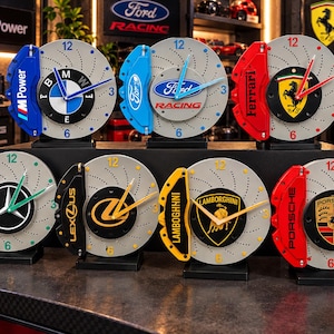 Può includere: Una collezione di sette orologi circolari progettati per assomigliare a dischi freno automobilistici con pinze colorate. Ogni orologio presenta al centro il logo di uno specifico marchio automobilistico: BMW, Ford, Ferrari, AMG, Lexus, Lamborghini e Porsche.
