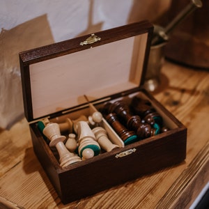 Wooden chess pieces in a chest