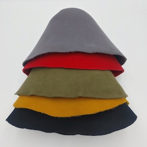 May include: Five felt hats stacked on top of each other. The hats are in the following order from top to bottom: grey, red, green, yellow, and black.