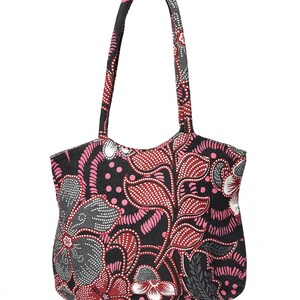 May include: A tote bag with a floral pattern in shades of pink, red, gray, and white on a black background. The bag has two handles and a rounded top. The floral design is intricate and detailed, with a batik-style appearance.