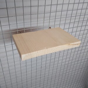 May include: A natural wood shelf with a light brown finish, attached to a wire cage with two metal hooks.