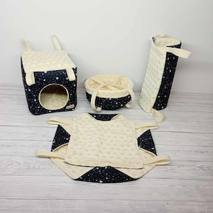 May include: A set of four small pet beds and a hanging hammock, all in a black and white starry print. The beds are made of soft fabric and have a cream-colored interior.