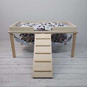 Peut inclure: Un lit pour animal domestique en bois avec une rampe et un hamac. Le lit est peint en blanc et est recouvert d'un tissu &agrave; imprim&eacute; panda noir et blanc. La rampe est en bois et comporte quatre marches. Le hamac est en tissu et est imprim&eacute; de pandas noirs et blancs.