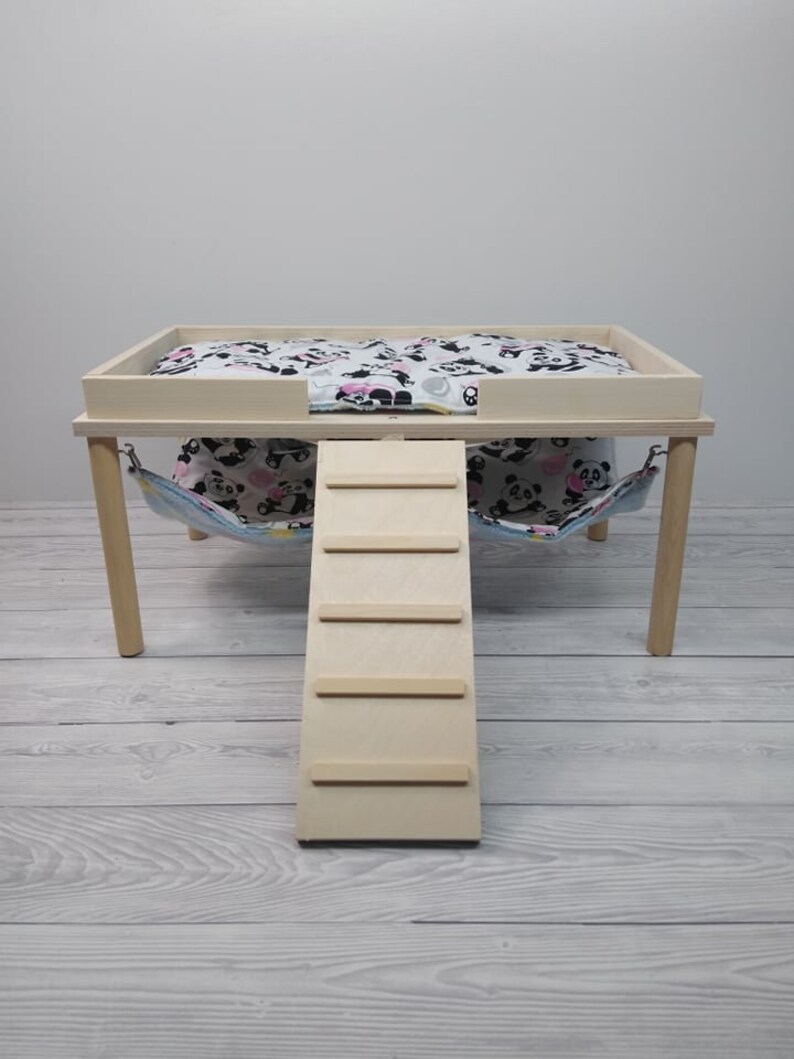 Peut inclure: Un lit pour animal domestique en bois avec une rampe et un hamac. Le lit est peint en blanc et est recouvert d'un tissu &agrave; imprim&eacute; panda noir et blanc. La rampe est en bois et comporte quatre marches. Le hamac est en tissu et est imprim&eacute; de pandas noirs et blancs.