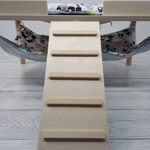 Peut inclure: Une rampe en bois avec cinq marches pour petits animaux de compagnie. La rampe est de couleur brun clair et a une finition en bois naturel. Elle est con&ccedil;ue pour &ecirc;tre utilis&eacute;e avec un lit pour animaux de compagnie ou une autre plateforme sur&eacute;lev&eacute;e.