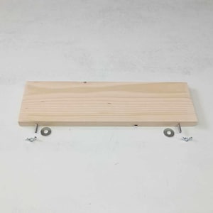 Op de afbeelding: Een simpel houten plank met twee metalen beugels en schroeven. De plank is gemaakt van onbehandeld hout en is klaar om te worden beitsen of geverfd.