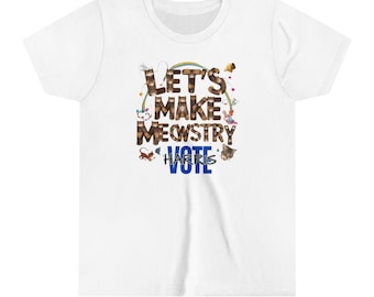 Puede incluir: Una camiseta blanca de manga corta con un estampado gráfico que incluye el texto LET'S MAKE MEWSTRY VOTE HARRIS. Las letras están rellenas con imágenes de gatos atigrados marrones, acompañadas de un arcoíris, ovillos y gatos pequeños.