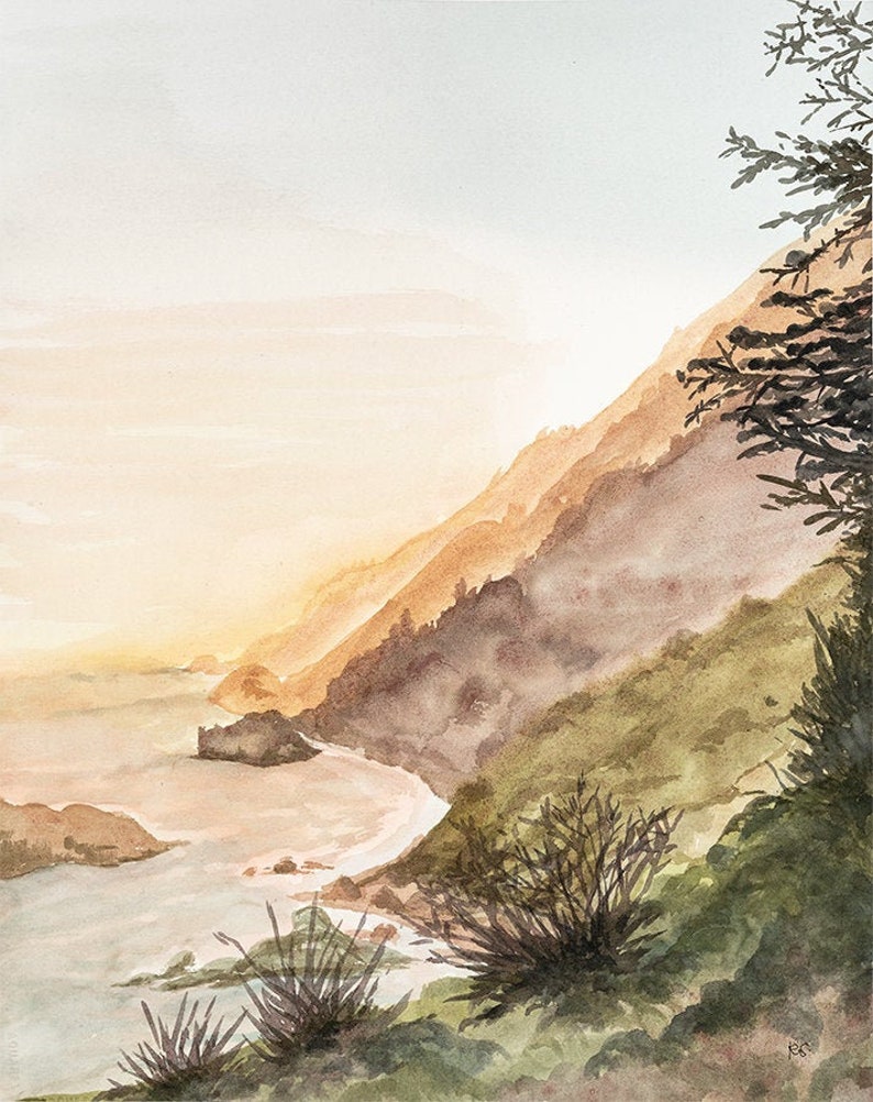 May include: A watercolor painting depicting a coastal landscape at sunset. The scene features a steep, grassy hillside sloping down toward the ocean, with rocky formations along the shoreline and dark, silhouetted evergreen trees in the foreground.