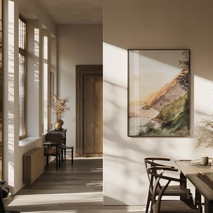 May include: A rectangular framed wall art print featuring a watercolor landscape of a coastal cliffside meeting the ocean at sunset, displayed on a neutral-toned interior wall within a room with wooden flooring and natural light streaming through windows.