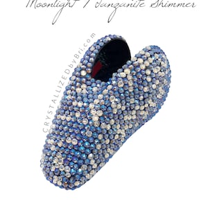 May include: A blue and silver crystal-covered shoe with the text "Moonlight / Tanzanite Shimmer" and "Crystallized by Bri.com". The shoe is covered in small, sparkling crystals.