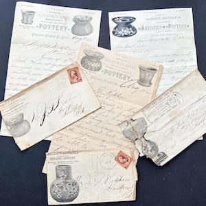 Pode incluir: Uma coleção de documentos e envelopes antigos de cerâmica Goodwin Brothers. Os documentos apresentam ilustrações de designs de cerâmica, texto manuscrito e selos postais vintage. Os itens estão dispostos em uma superfície escura.
