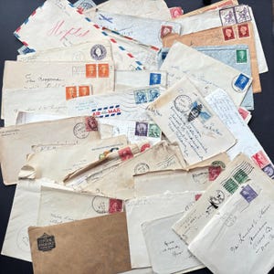 May include: A pile of antique envelopes, many with stamps and postmarks. The envelopes are in various shades, from cream to beige, and have handwritten addresses and the words "Air Mail". Some stamps show historical figures.